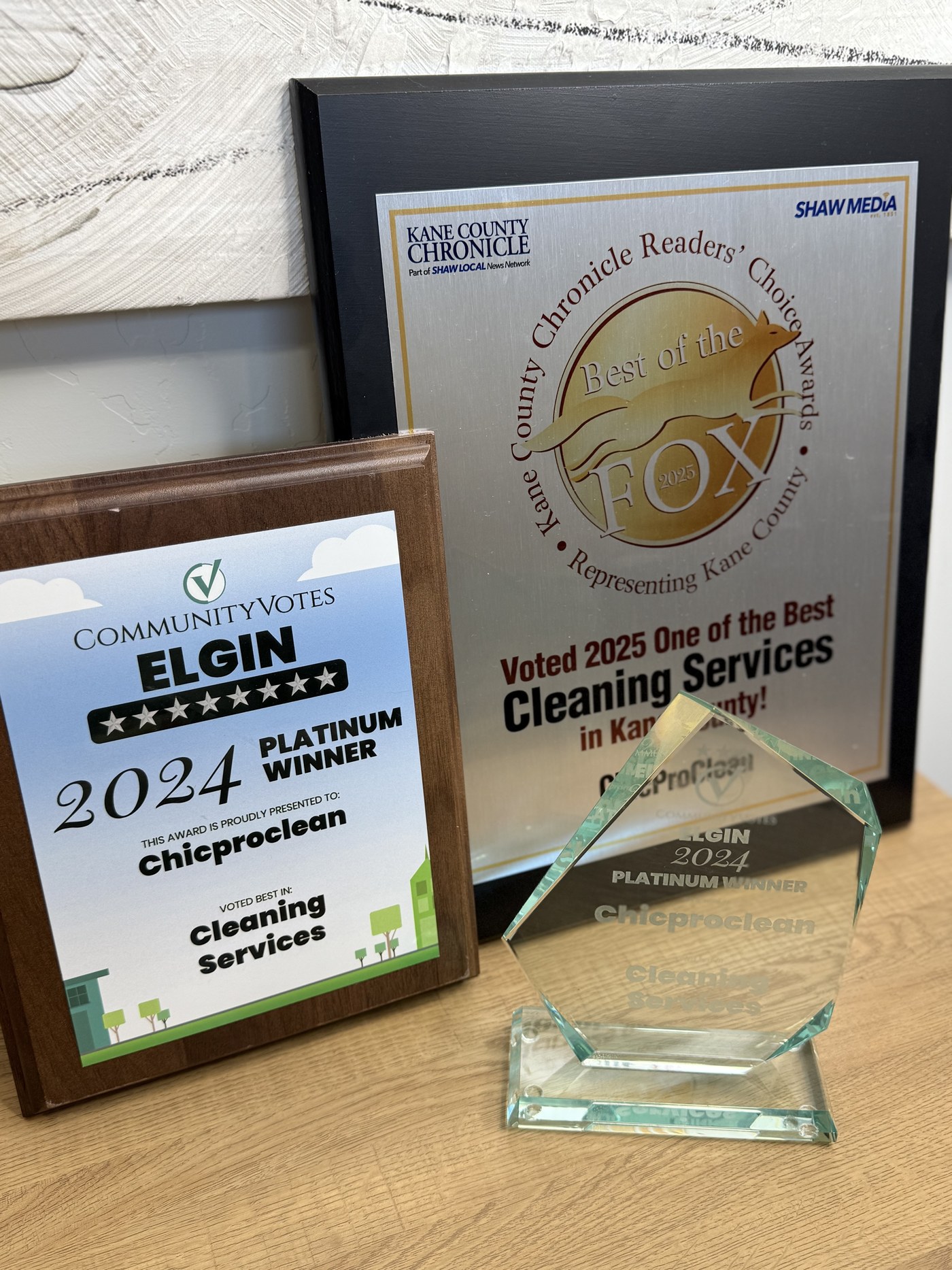 ChicProClean's four community awards — CommunityVotes Elgin Platinum Winner plaques and Kane County Chronicle Best of the Fox Reader's Choice Award displayed together